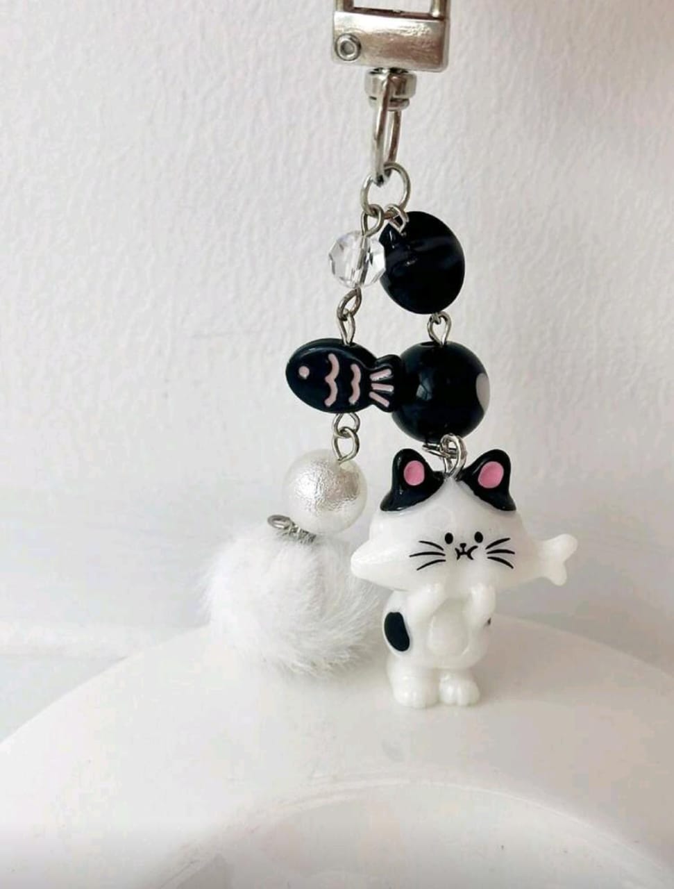 Llavero de gato blanco y negro con dije de pescado y estrella