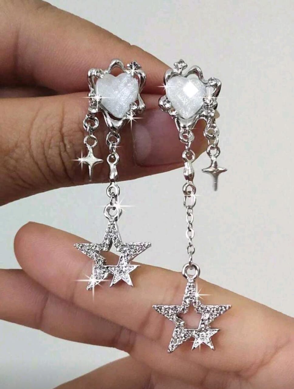 Aretes plateados con piedra de corazon blanca y estrellas