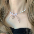 Collar de perlas falsas y colgante con lazo y dije de corazón